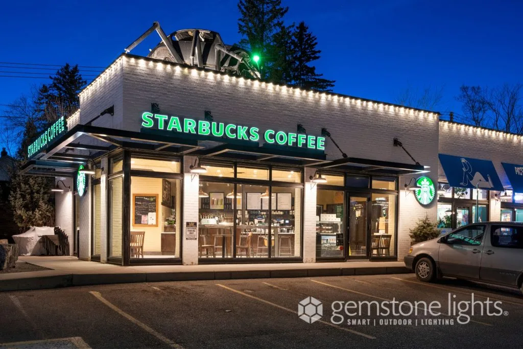 Architectural lighting enhances the cozy ambiance of a coffee shop at dusk