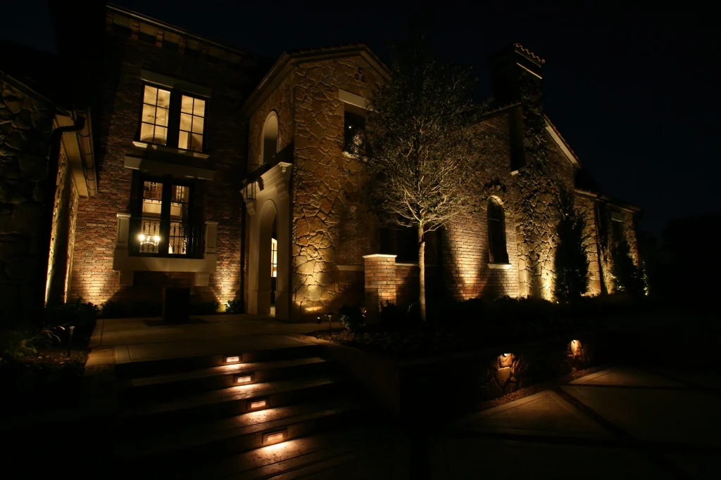 A charming stone house is elegantly illuminated against a dark night sky
