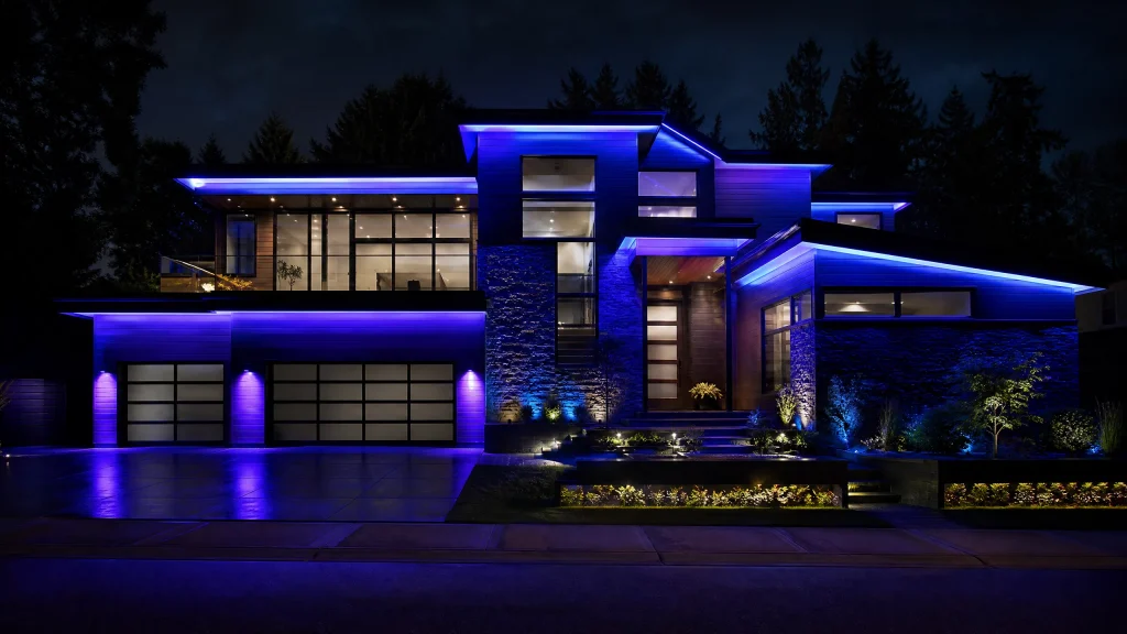A modern house glows with vibrant blue lighting at night