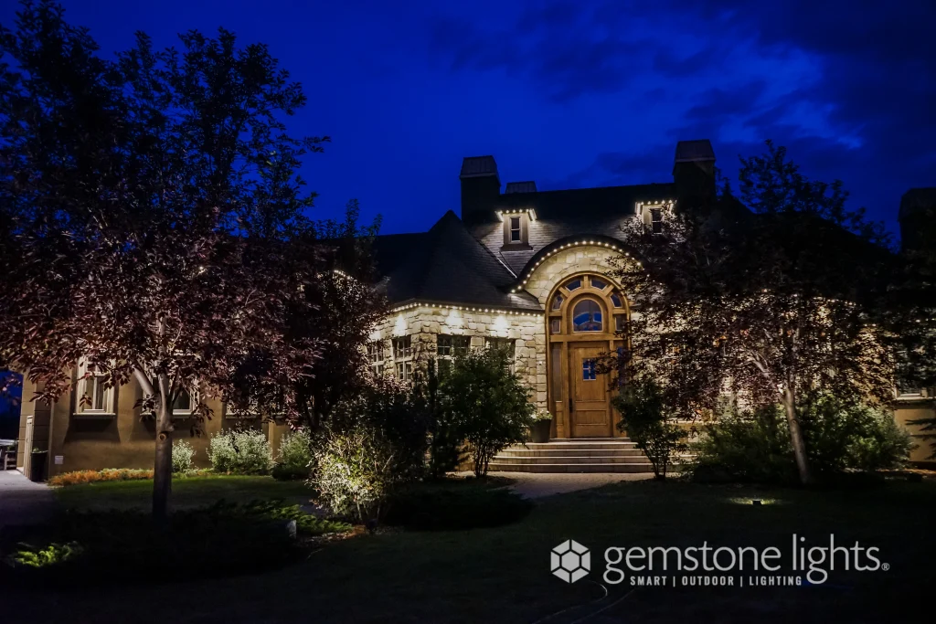 A beautifully lit house showcases decorative lighting in a serene nighttime setting