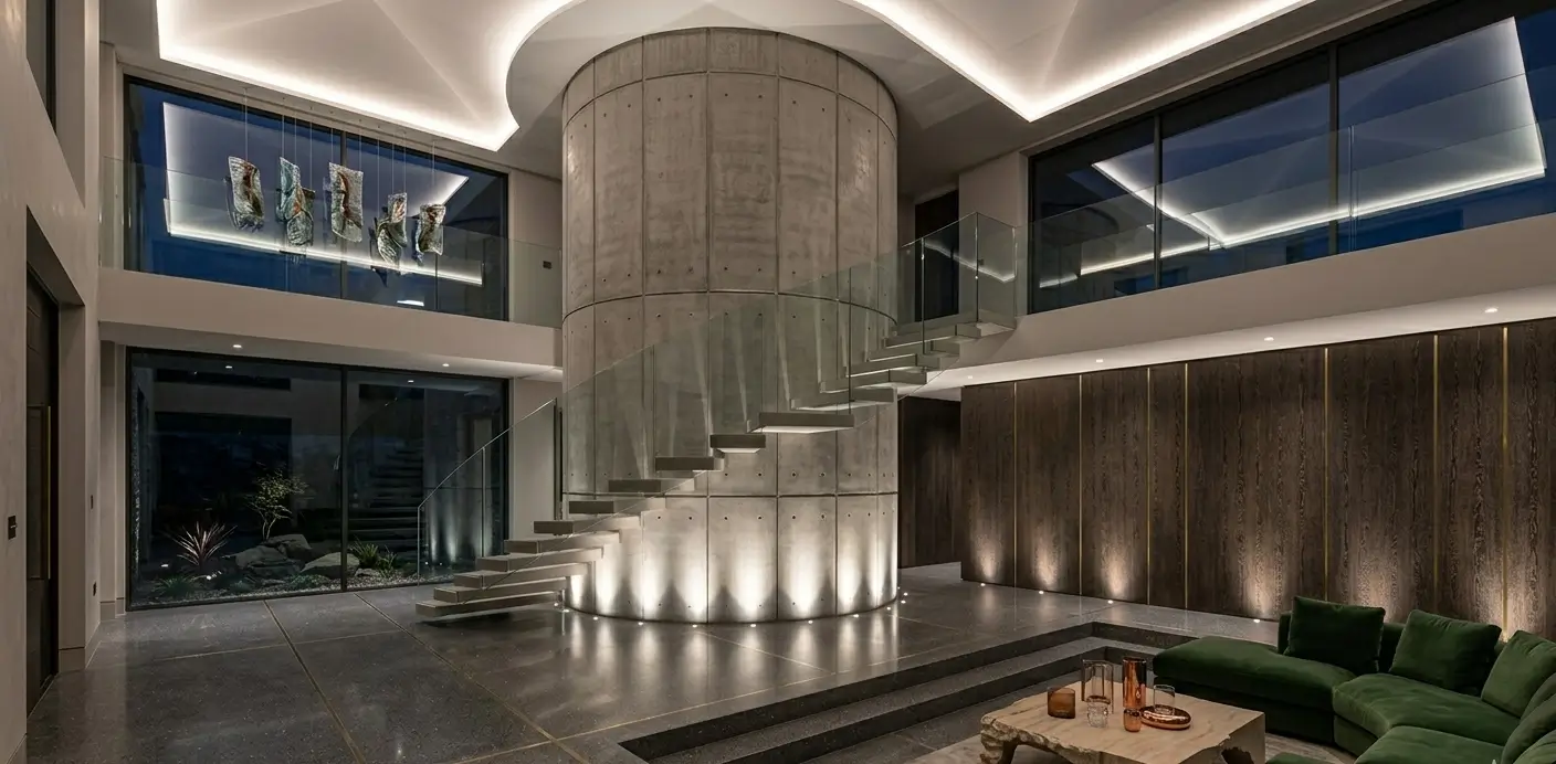 A modern, minimalist interior features a central staircase and ambient lighting