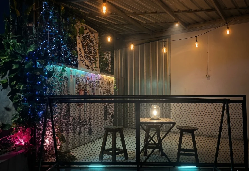 A cozy outdoor space illuminated by soft lights and surrounded by greenery