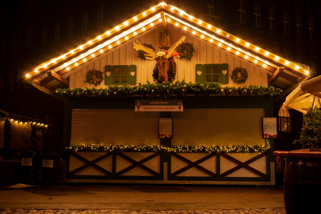 A cozy wooden structure adorned with festive lights and greenery