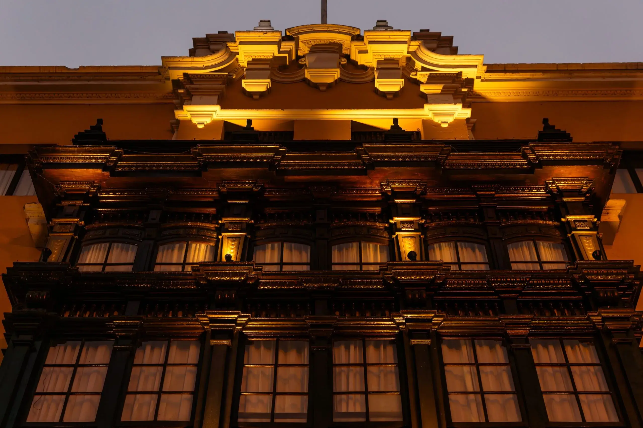 Illuminated ornate architecture highlights intricate details against a dusk sky