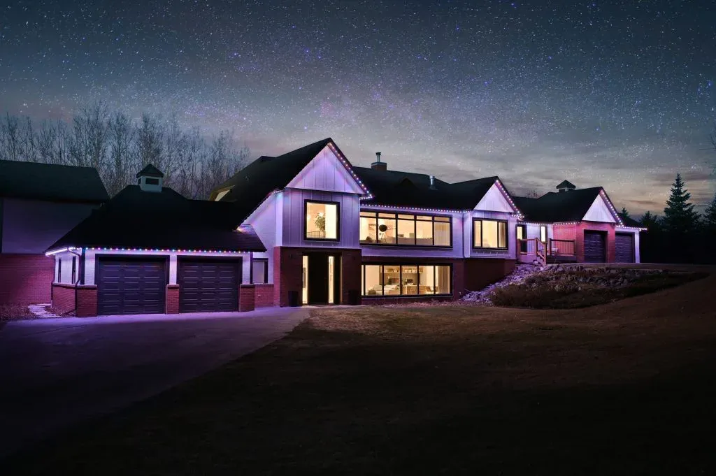 A modern house glows under a starry sky, highlighting its architectural features