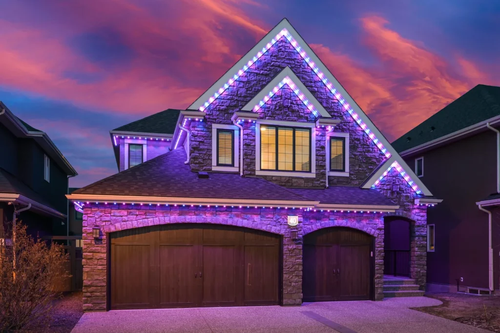 Permanent blue roofline lighting on a stone-front home