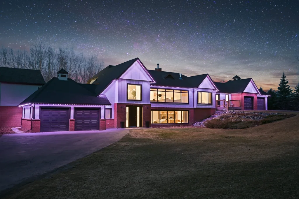 Permanent purple roofline lighting on a ranch home at night