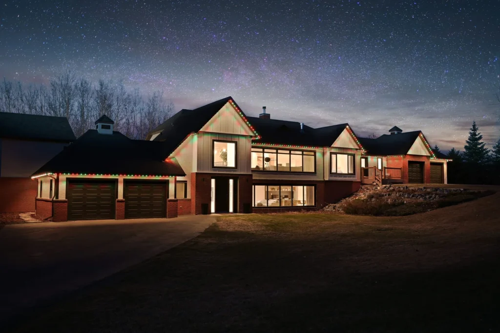 Permanent roofline lighting on a Colorado home under a night sky